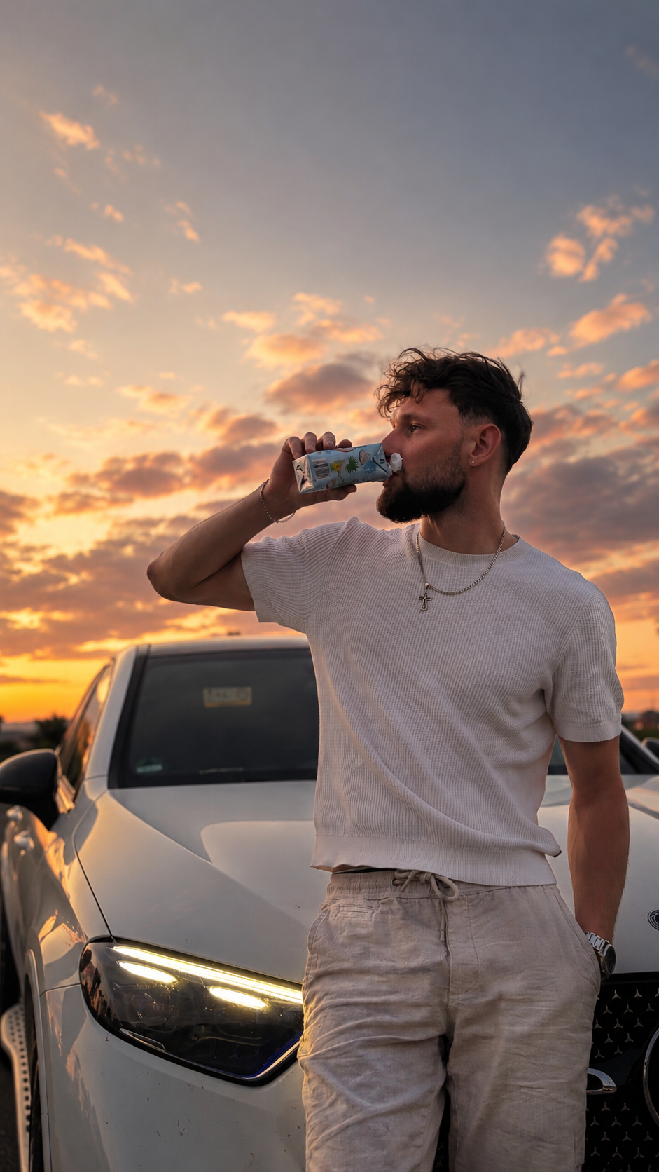 Johann vor einem Auto bei Sonnenuntergang